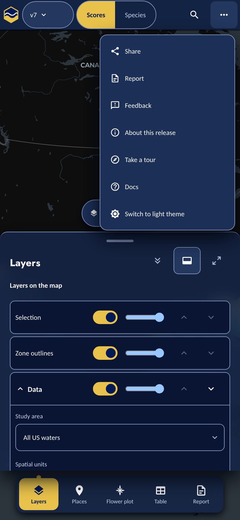 The phone's More menu open: Share, Report, Feedback, About this release, Take a tour, Docs, and Switch to light theme, above the bottom tab bar.